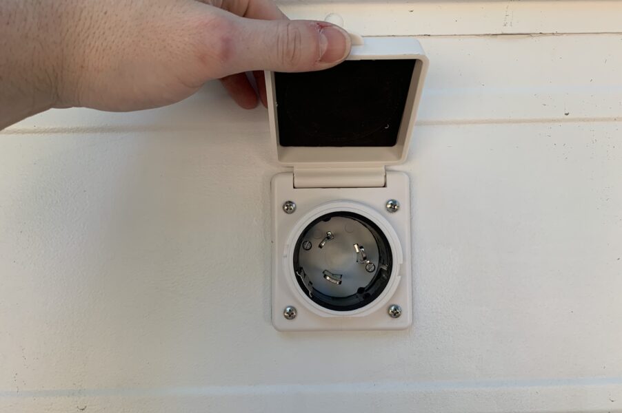 a power inlet installed in the side of our skoolie